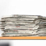 Das Bild zeigt einen Zeitungsstapel. Der Artikel geht der Frage nach, ob der Trend des Clickbaiting auch im Printjournalismus zu schlechten Überschriften führt.